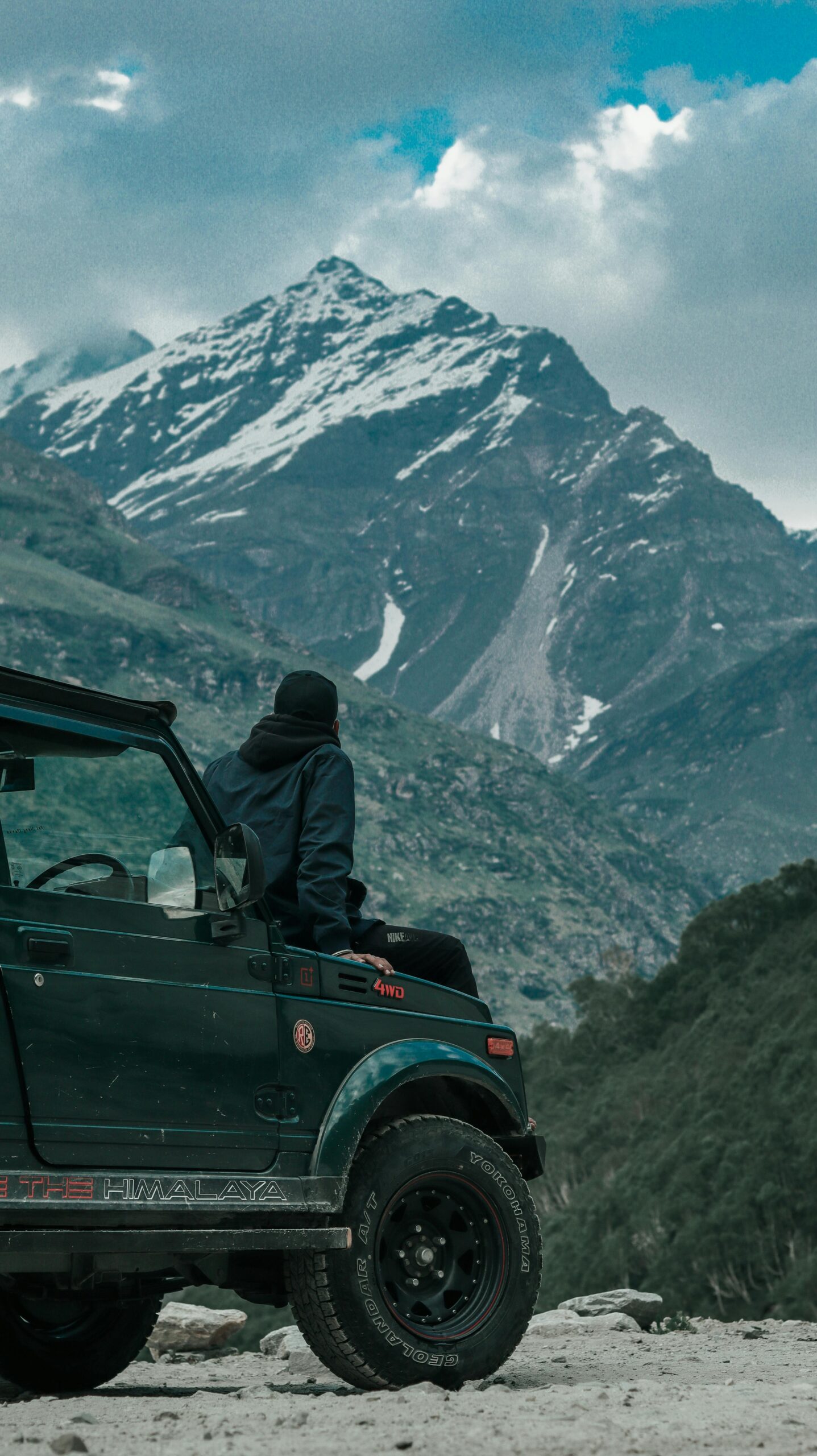 Person in a jeep exploring the stunning mountain landscape of HP, India.