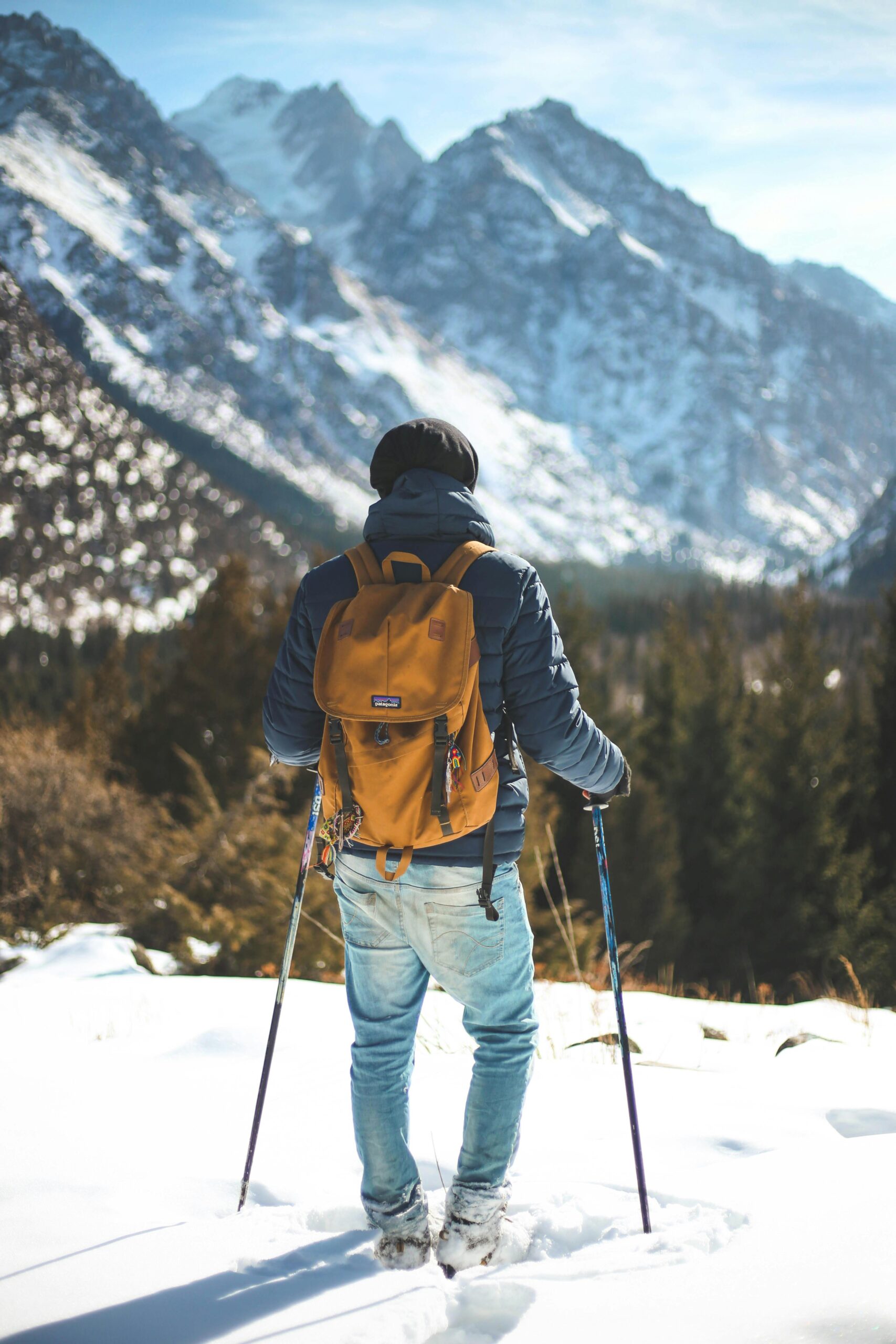 A hiker with a backpack traverses a snowy mountain landscape, showcasing winter exploration and adventure.